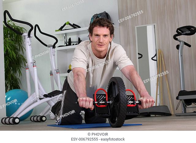 Man using an ab roller (exercise wheel)