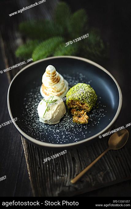 Winter dessert with pine ice cream, meringue cream trees and stollen dumplings
