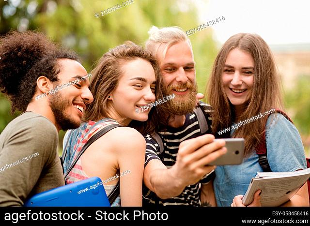 College friends smiling for selfie. Boys and girls posing and smiling for selfie