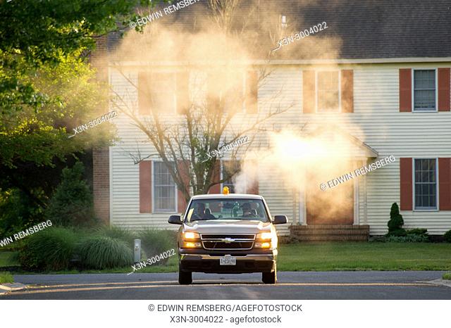 Salisbury Maryland USA - Mosquito Control Truck drives through suburban neighborhood spraying insecticide to control mosquito population