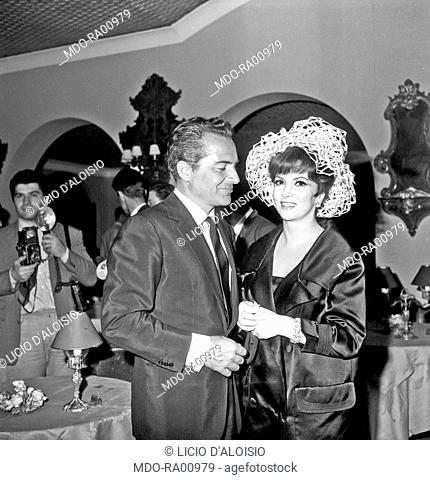 Italian actress Gina Lollobrigida being photographed beside Italian actor Rossano Brazzi at the party in a villa in Grottaferrata, Roma Castles