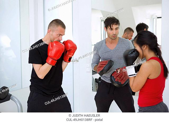 Trainer working with boxers in gym