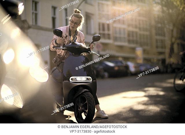 Woman on motor scooter, in Berlin, Germany