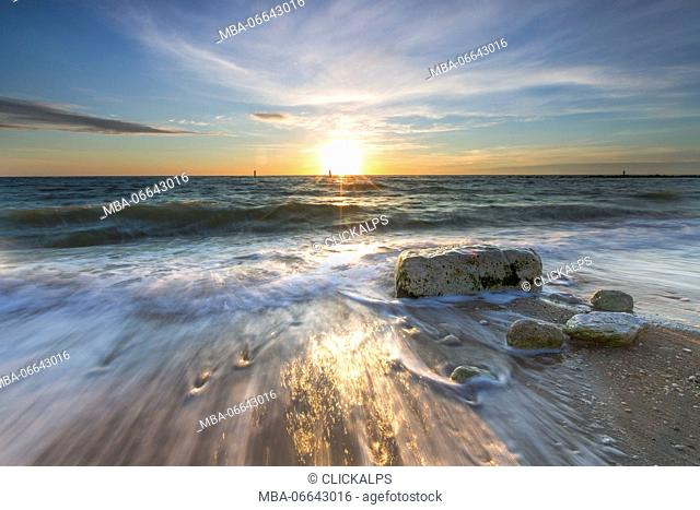 Waves crashing on the sandy beach framed by sunrise Porto Recanati Province of Macerata Conero Riviera Marche Italy Europe