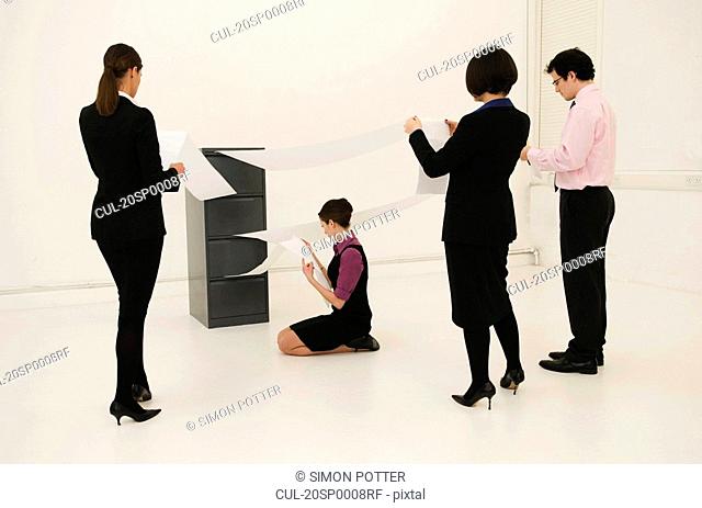 4 workers look for data in cabinet