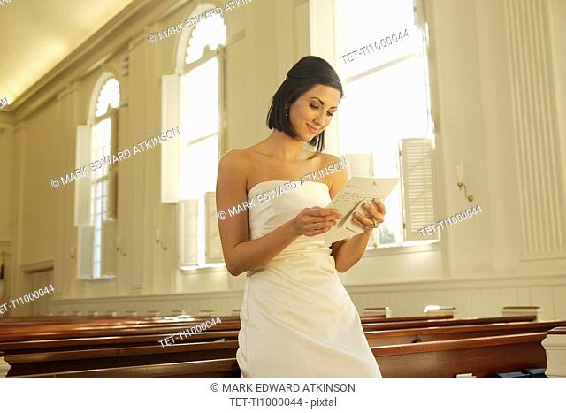 Bride reading letter in church