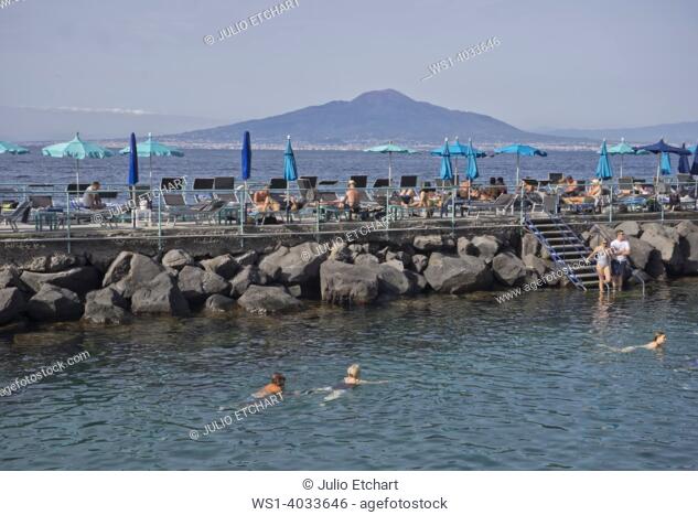 Tourists swimming and sunbathing at a private lido beach resort in the seaside resort of Sorrento near Naples, Italy