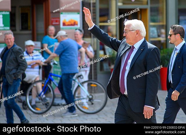 10 May 2022, Saxony-Anhalt, Quedlinburg: German President Frank-Walter Steinmeier walks through the marketplace of the town of Quedlinburg, waving to passers-by
