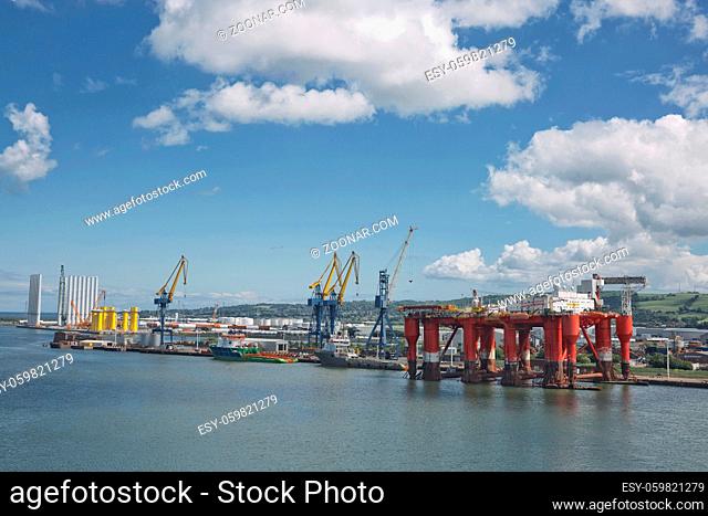 Belfast, Ireland - June 9, 2017: Large industrial cranes loading container ship in Belfast Port in Ireland