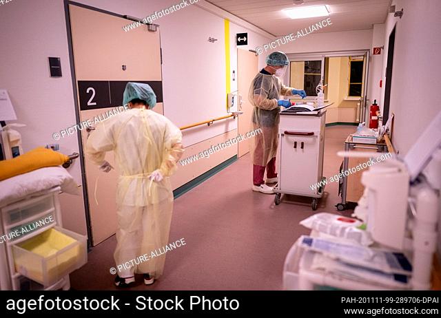 10 November 2020, Berlin: Nurses in protective gear with mouth and nose cover, face mask, gown and hood at the Covid 19 ward of Bethel Hospital Berlin prepare...