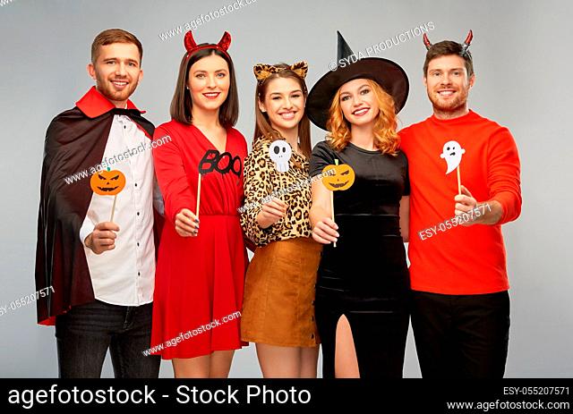 friends in halloween costumes with party props