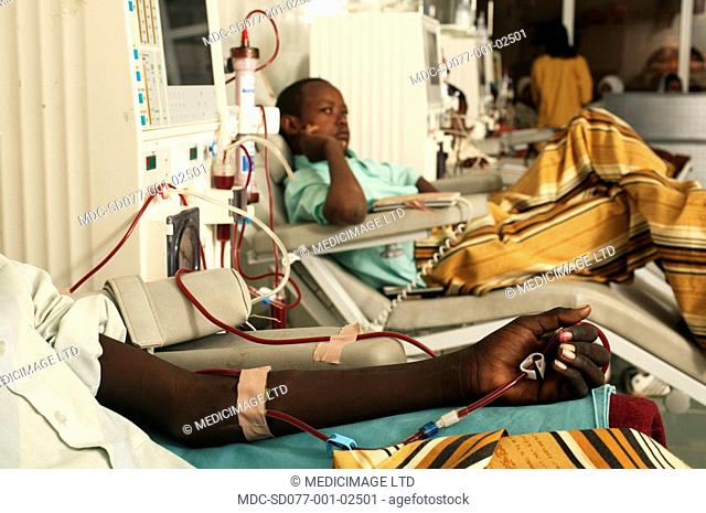 Young patients lie in wait as they undergo kidney dialysis. The kidney dialysis machine acts as an artificial kidney. It extracts blood from the patient to...