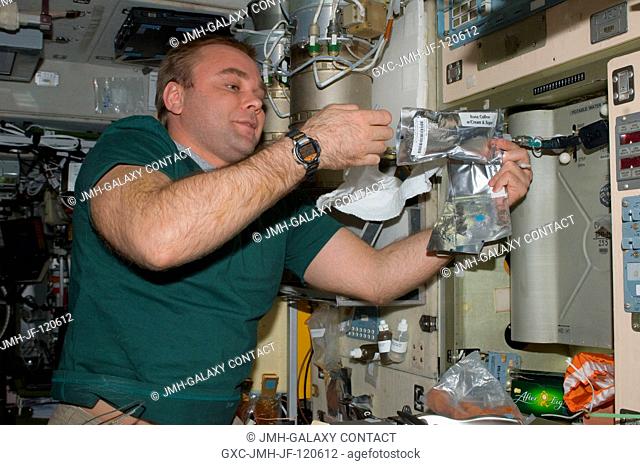 Russian cosmonaut Maxim Suraev, Expedition 22 flight engineer, adds potable water to a soft beverage container at the galley in the Zvezda Service Module of the...