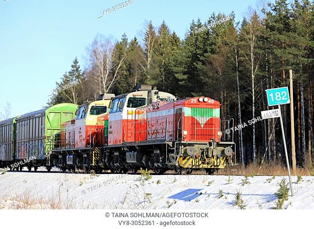 Two diesel engines in front of freight train at speed on sunny day of winter in Raasepori, Finland - March 16, 2018