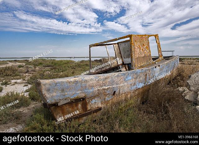 abandoned boat on marsh vegetation on the Guadalquivir river over blue sky and water, Trebujena, Seville, Andalucia, Spain