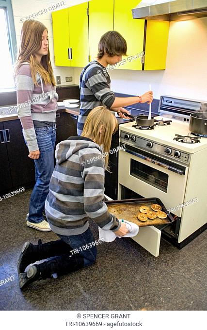Eighth-grade boys and girls at a Southern California middle school toast bagels in their home economics elective class