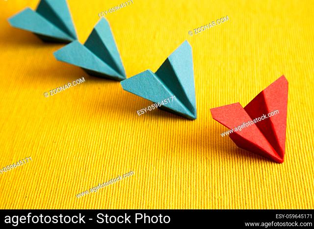 Row of paper plane on yellow fabric background. leadership concept