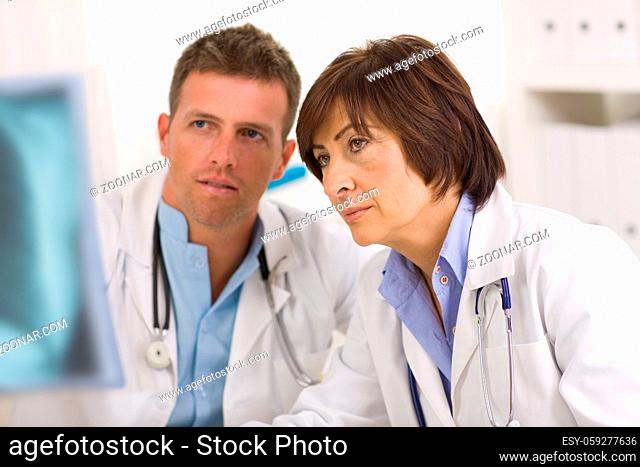 Doctors coworking looking at x-ray image at office