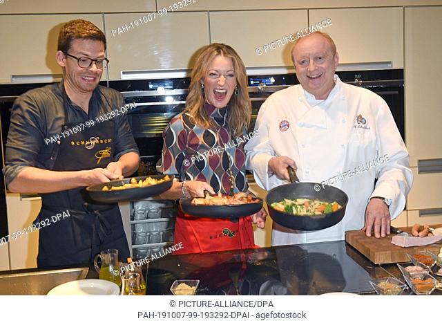 07 October 2019, Bavaria, Munich: The cabaret artists Martin Frank (l) and Monika Gruber and star chef Alfons Schuhbeck are cooking during a press conference...