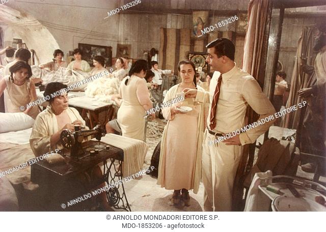 Italian actor and director Giancarlo Giannini looking at Italian actress Elena Fiore sitting at the typewriter in a scene from the film Seven Beauties