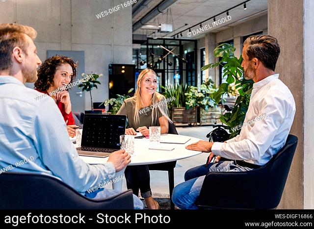 Smiling coworkers attending meeting in office
