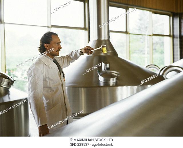 Brewer assessing a beer sample in brewing room