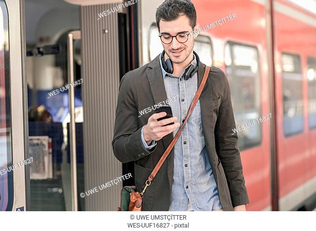 Young man using cell phone at commuter train
