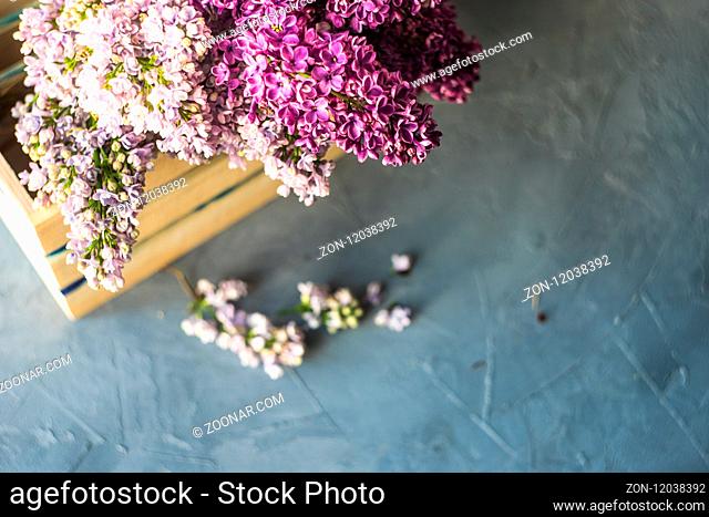Beautiful bunch of lilac flowers in a wooden box on rustic background with copy space