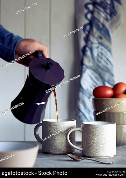 Man pouring coffee into mug