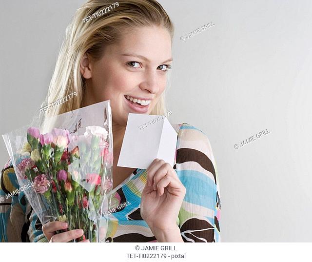 Woman holding flowers and card