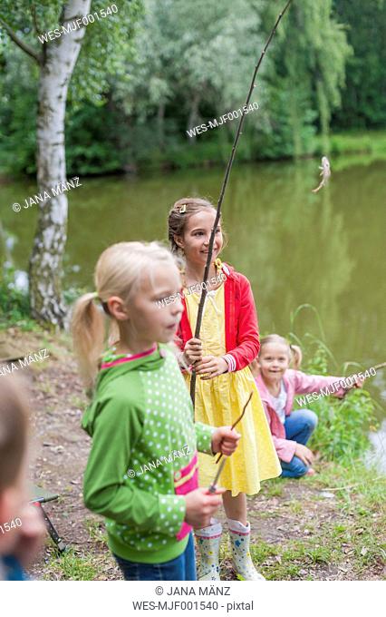 Germany, Girls with rods and small fish