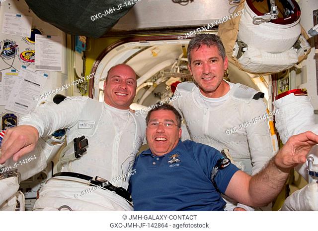 Garrett Reisman (left) Stephen Bowen, and Michael Good (right) pose for a picture before Extravehicular Activity 3 (EVA-3)