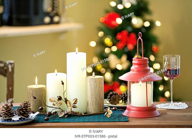 Christmas Candle And Lantern On Table In Front Of Decorative Christmas Tree