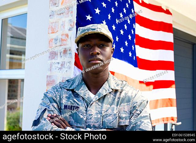 African american mid adult army soldier in camouflage clothing with arms crossed against flag