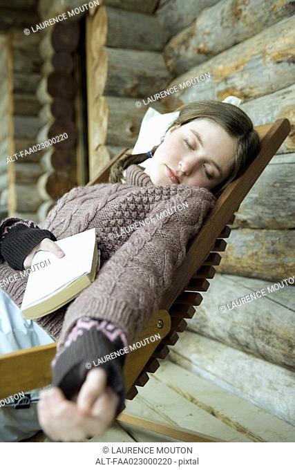 Teen girl in winter clothes, falling asleep while holding book
