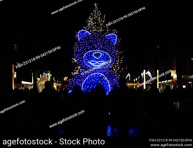15 December 2023, Saxony, Dresden: An illuminated teddy bear stands at the ""Augustusmarkt"" Christmas market on the main street