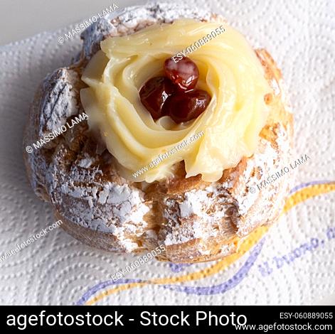 Zeppole of Saint Joseph, Italian pastry with flour, sugar, eggs, oil, decorated with a sour cherry. Father's Day cake