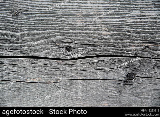 Faded wooden surface with knotholes and cracks