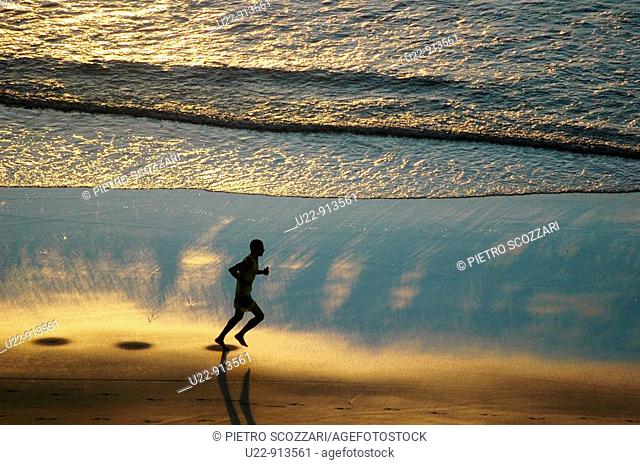 Jericoacoara (Ceara, Brazil): a man jogging at sunset along the beach