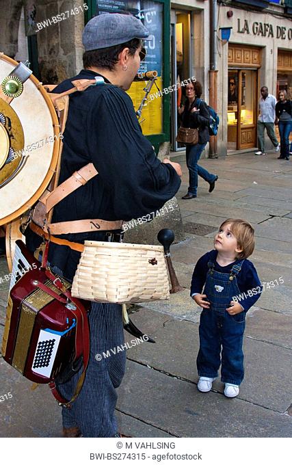 little boy listen to a street muscian, Spain, Galicia, A Corua, Santiago De Compostela