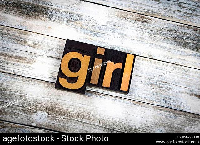 The word ""girl"" written in wooden letterpress type on a white washed old wooden boards background