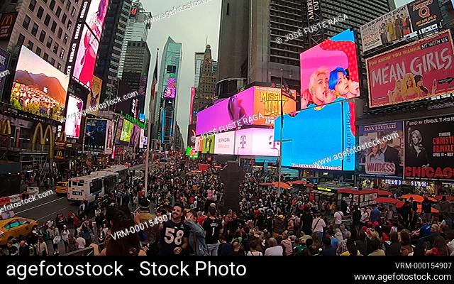 Bright neon signage flashes over crowds in Times Square