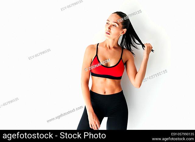 Young beautiful woman in sportswear posing on white background. Female beauty concept
