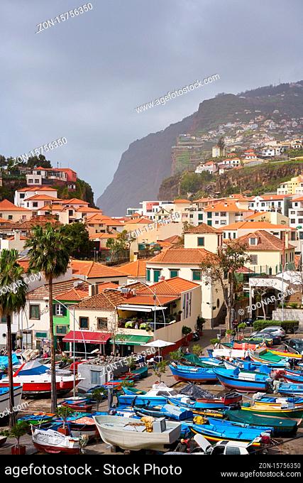 View of Câmara de Lobos in Madeira with Cape Girão on the background and boats at the marina