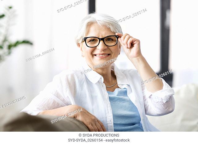 portrait of happy senior woman in glasses at home