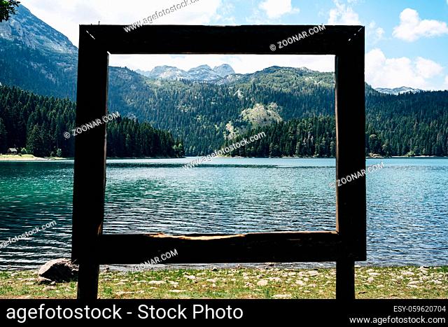 Picturesque view of the lake through the wooden frame on the beach