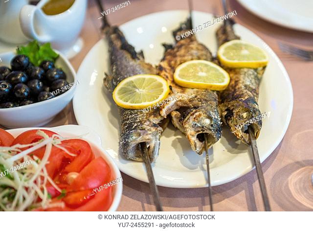 roasted fish served with lemon slices - traditional food in Georgia