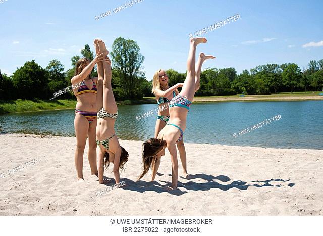 Girls doing gymnastics on the beach of a lake