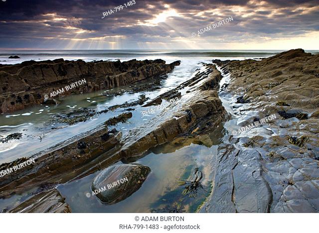 Rockpools and ledges beneath a cloudy sky, Sandymouth Beach, Cornwall, England, United Kingdom, Europe