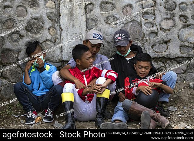 A young jockeys get ready to race at HM Hasan's Field, Blang Bebangka, Aceh Tengah District, Aceh Province, Indonesia, Sunday 1 September 2019